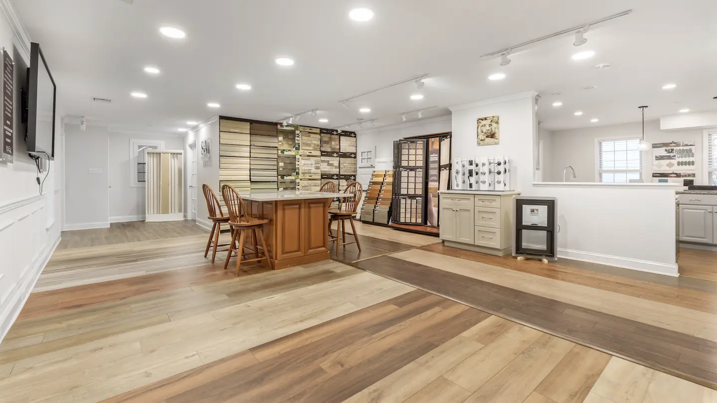 Open design center with flooring displays, sample walls, seating island, and bright recessed lighting for selections.  
