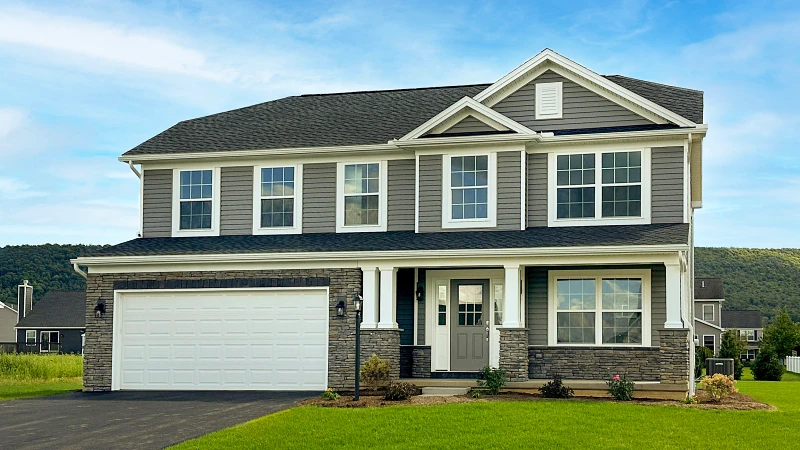 Stage 7 - Welcome Home.jpg: Completed two-story new home exterior with landscaped yard, covered porch, and attached garage, ready for move-in.