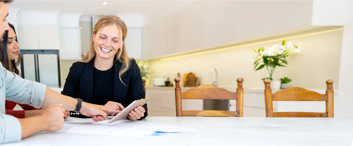 Three individuals looking at a tablet device