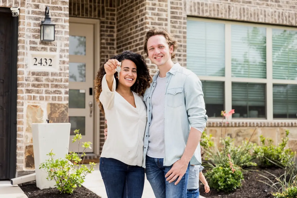 Couple displaying house keys of their new home.